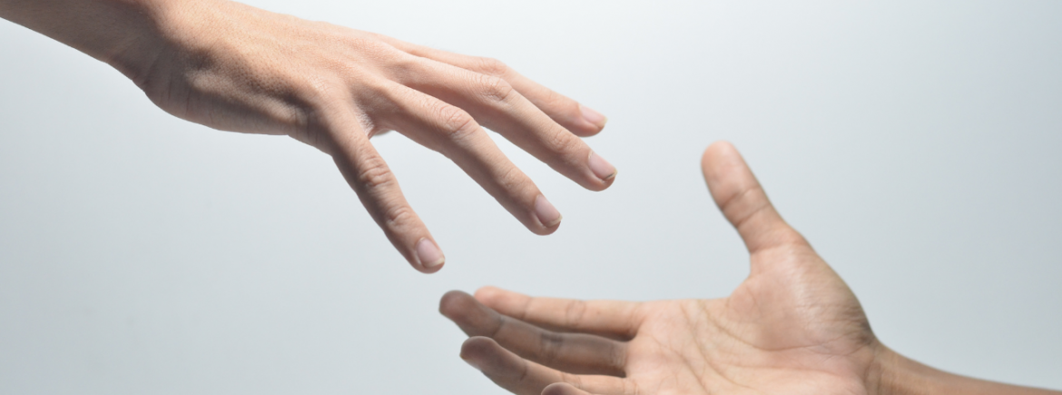 GBMpic_ Zwei einander entgegengestreckte Hände vor hellem Hintergrund.